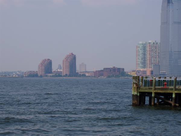 Wooden pier on the Hudson, Jersey City skyscrapers in the haze