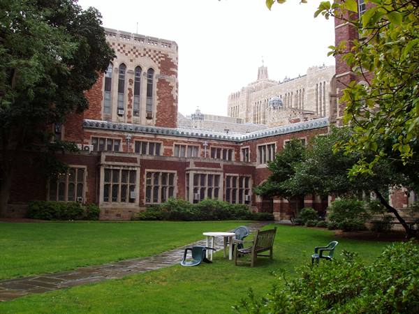 Green courtyard with benches and chairs among Yale's neo-Gothic brick buildings