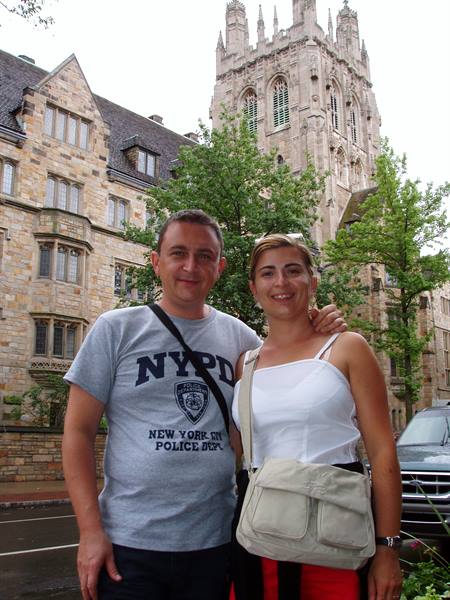 Couple in NYPD shirt in front of Yale's gothic stone towers