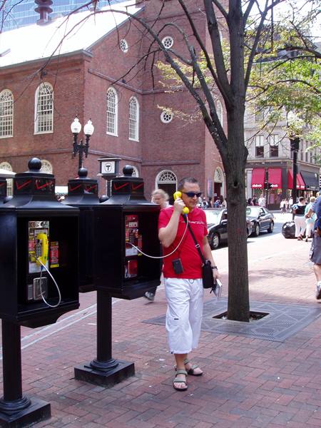 Man talks on a black payphone beside the Old South Meeting House in Boston