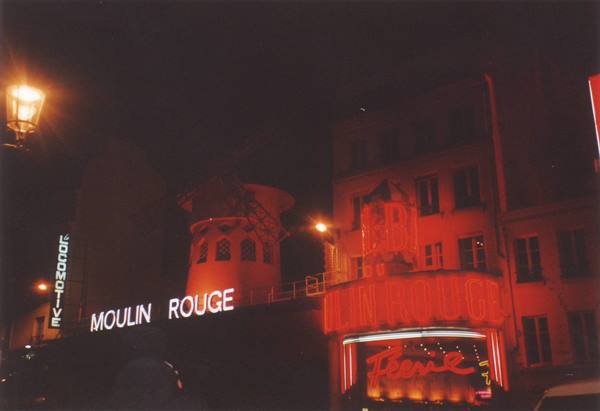 Red neon sign of the Moulin Rouge lit at night in Paris
