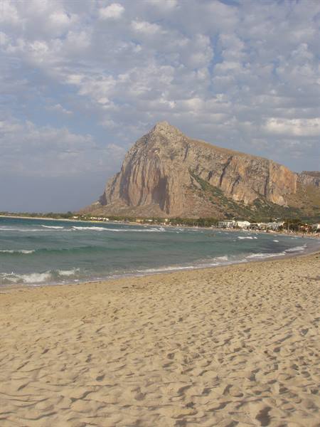 Footprinted sand and waves in front of San Vito Lo Capo mountain