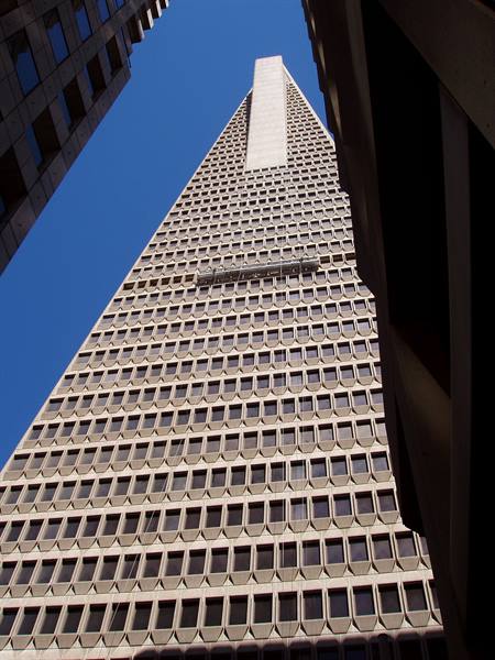 Pyramid skyscraper with concrete grid facade under blue sky, San Francisco