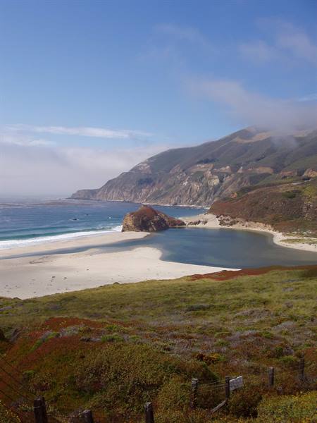 Beach and lagoon between green cliffs under low clouds, Big Sur