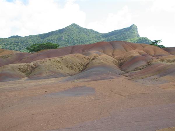 Seven Coloured Earths of Chamarel, red and purple sand dunes beneath green peaks