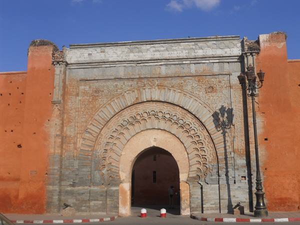 Bab Agnaou gate in Marrakech, carved stone arch under blue sky