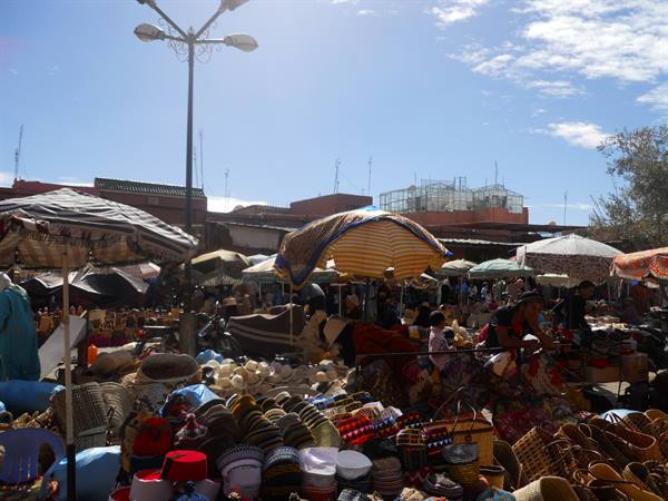Open-air market with colorful umbrellas and woven baskets for sale under the sun
