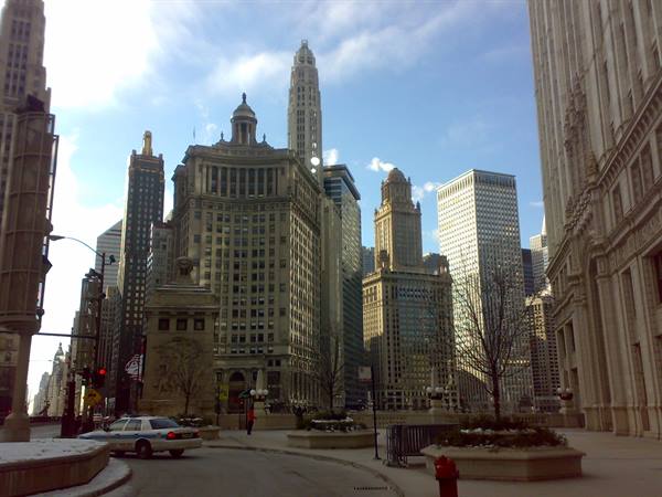 Historic Chicago skyscrapers along the river, snow on ground and a taxi