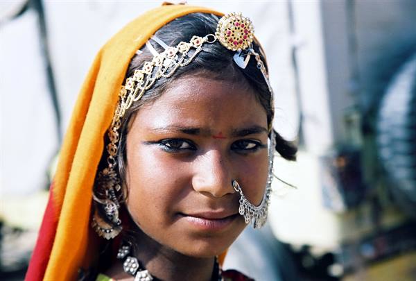 Girl wearing silver nose ring, traditional jewelry, intense gaze
