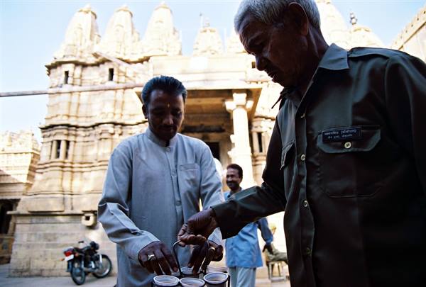 Guard pours tea outside Ranakpur Jain temple, morning light