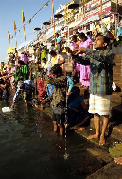 Pilgrims offering water to the Ganges river on Varanasi ghats