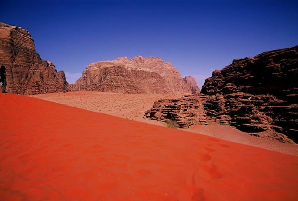Red sand dune between sandstone cliffs in Wadi Rum desert