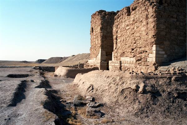 Ancient mud-brick walls beside a dried canal, morning light