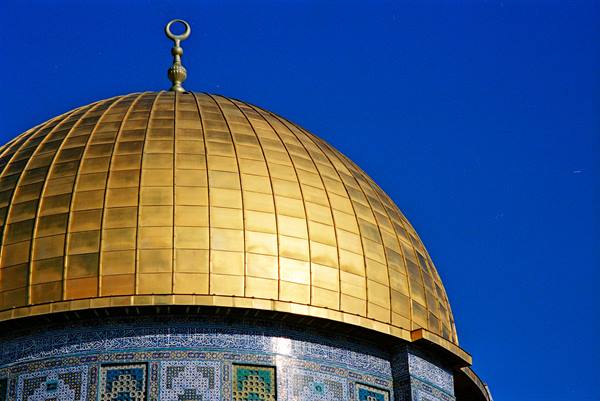 Golden dome of the Dome of the Rock in Jerusalem against a blue sky