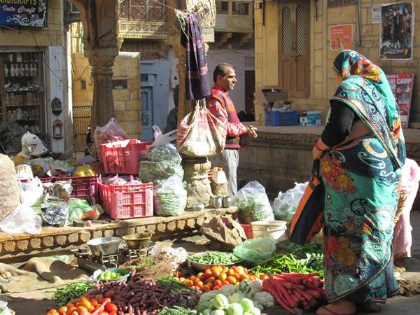 Woman in green sari buys vegetables at Jaisalmer open-air market