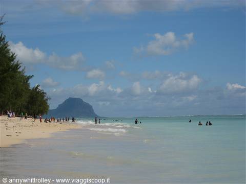 Swimmers on a pale sand beach in front of Le Morne Brabant mountain