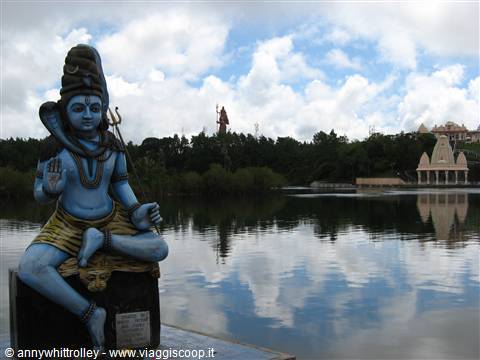 Blue Shiva statue seated beside the sacred Ganga Talao lake