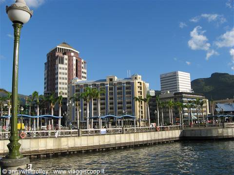 Port Louis waterfront: skyscrapers, palm trees and lamppost on the pier