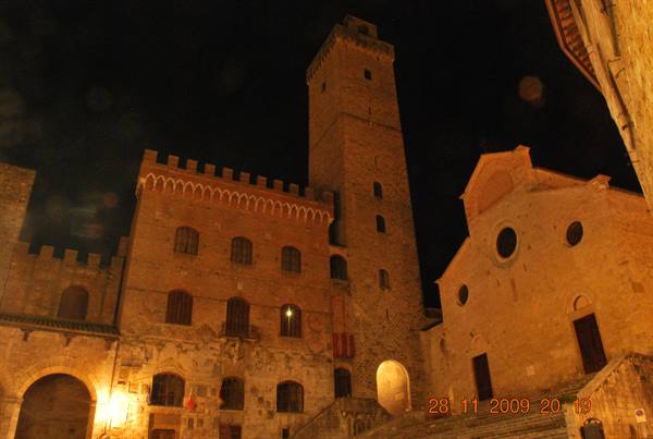 Night view of San Gimignano: medieval tower and cathedral lit on the square