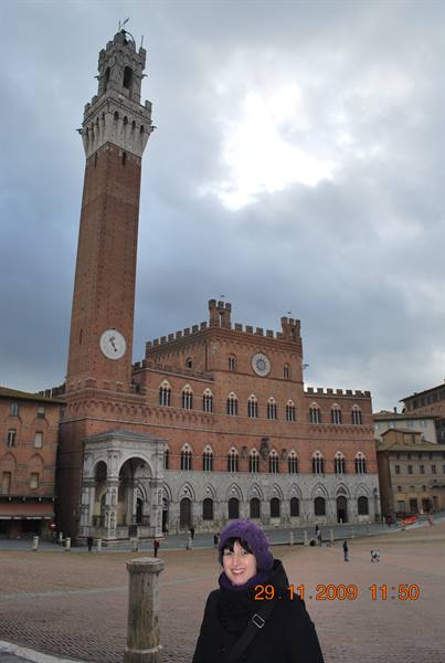 Smiling woman in Piazza del Campo, Siena, beneath the Torre del Mangia