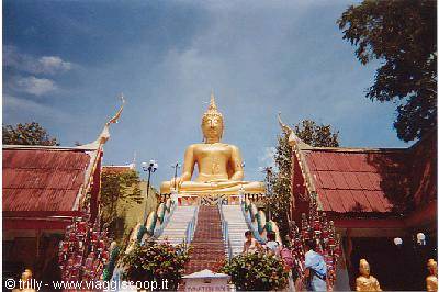 Golden Big Buddha seated on the staircase at Wat Phra Yai, blue sky