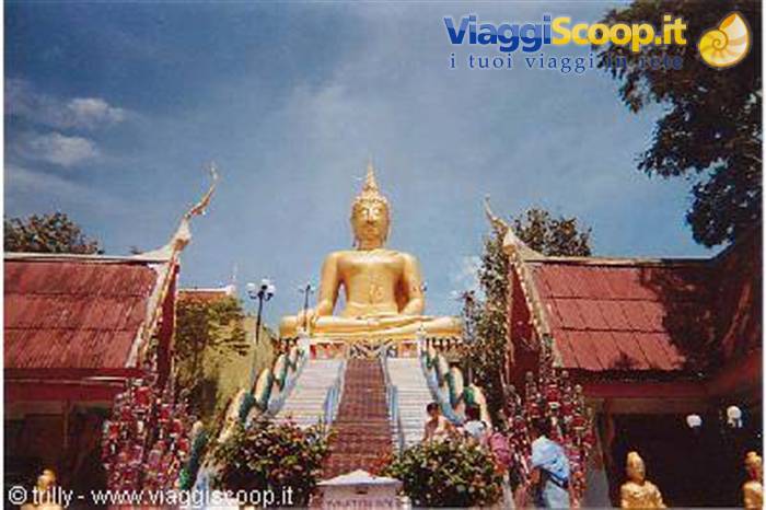 Golden Big Buddha seated on the staircase at Wat Phra Yai, blue sky