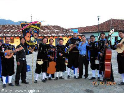 Andean musicians in black traditional costumes with charango and double bass on colonial square