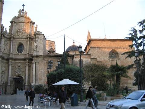 Baroque cathedral facade of Murcia at dusk, with pedestrians and outdoor café