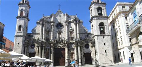 Havana Cathedral, stone facade with two asymmetric towers, umbrellas on the square
