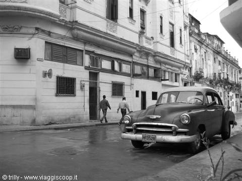 Vintage Chevrolet parked in front of colonial buildings along the street