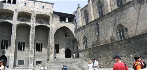 Tourists on stone steps by the Palau Reial Major at Plaça del Rei, Barcelona