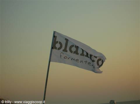 White Blanc Formentera flag waving in the wind against golden sky