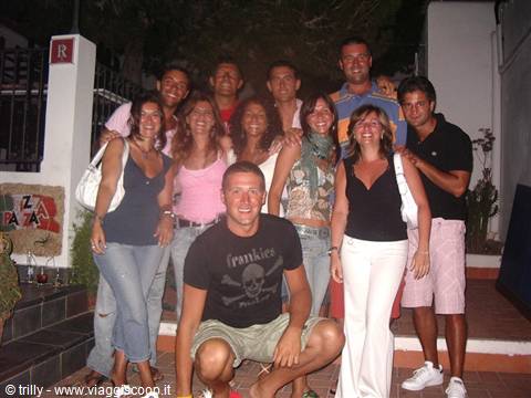 Group of friends posing together at night outside a lit venue