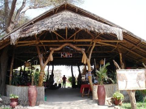 Thatched-roof pavilion built of wooden logs, clay pots and Kibo sign