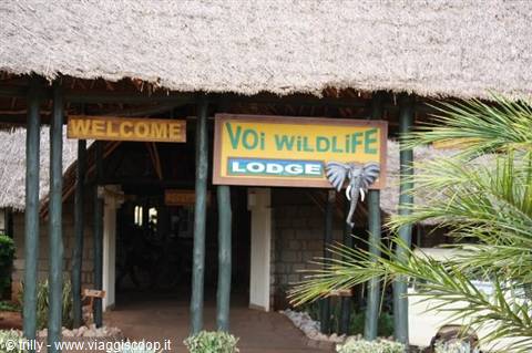 Thatched entrance of Voi Wildlife Lodge with welcome sign and palm frond