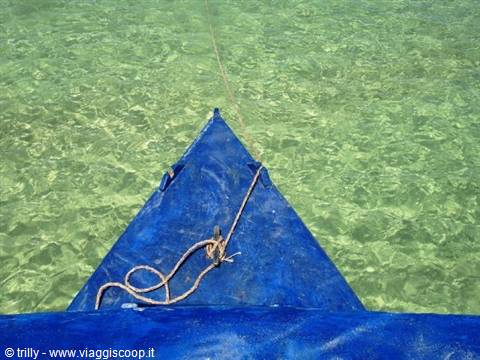 Blue boat bow over clear green water, knotted rope