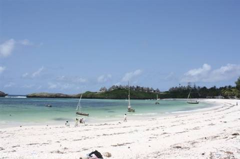 white sand beach with sailboats and turquoise water