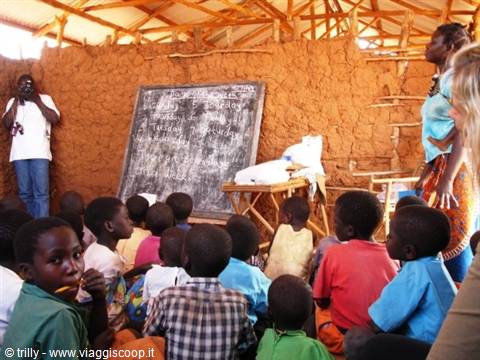 Children in a mud-walled classroom with blackboard, rural African school