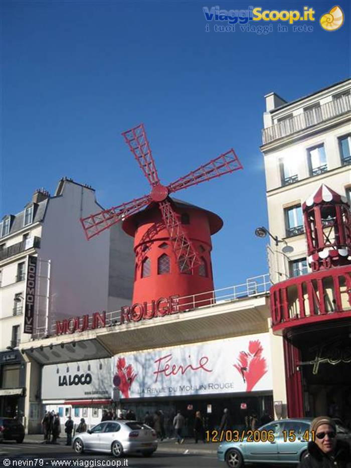 The red windmill of the Moulin Rouge in Paris under blue sky
