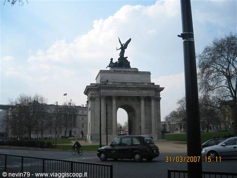 Wellington Arch at Hyde Park Corner, London, with black taxi and cyclist under clouds