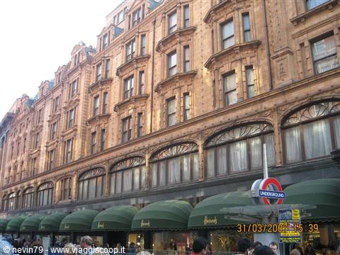 Harrods' terracotta Victorian facade with green awnings and Underground roundel sign