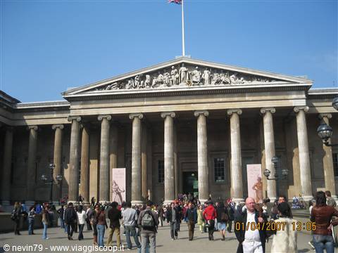 Tourists in front of the stone columns of the British Museum facade in London