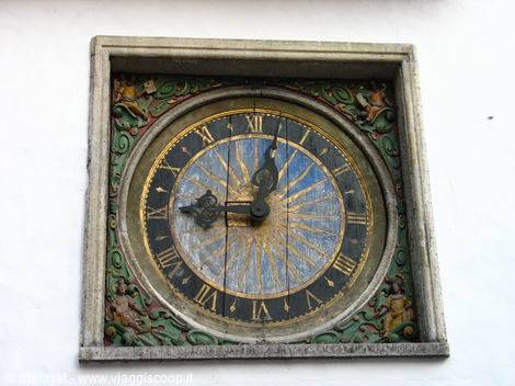 Antique painted clock in gold and blue on white facade