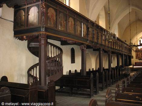 Painted wooden gallery with spiral staircase inside a Gothic church