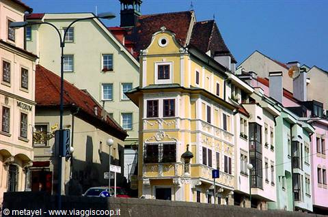 Pastel-colored houses with ornate yellow baroque facade along the Drava in Maribor