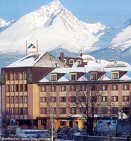 Snow-covered Slovenská Pošta hotel in front of snowy High Tatras peaks