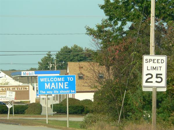 Blue Welcome to Maine sign beside speed limit 25, Mobil station