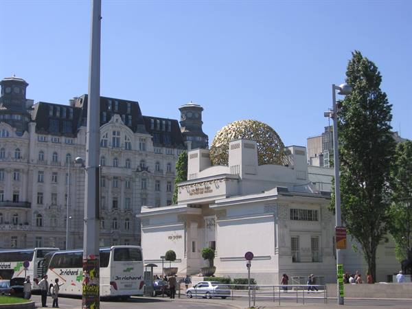 Vienna Secession building, golden dome of aluminum leaves, buses and pedestrians under sun