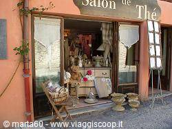 Entrance of a French salon de thé with wooden door, wicker basket and terracotta pots