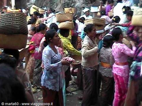 Balinese women carrying fruit offerings in woven baskets at the market